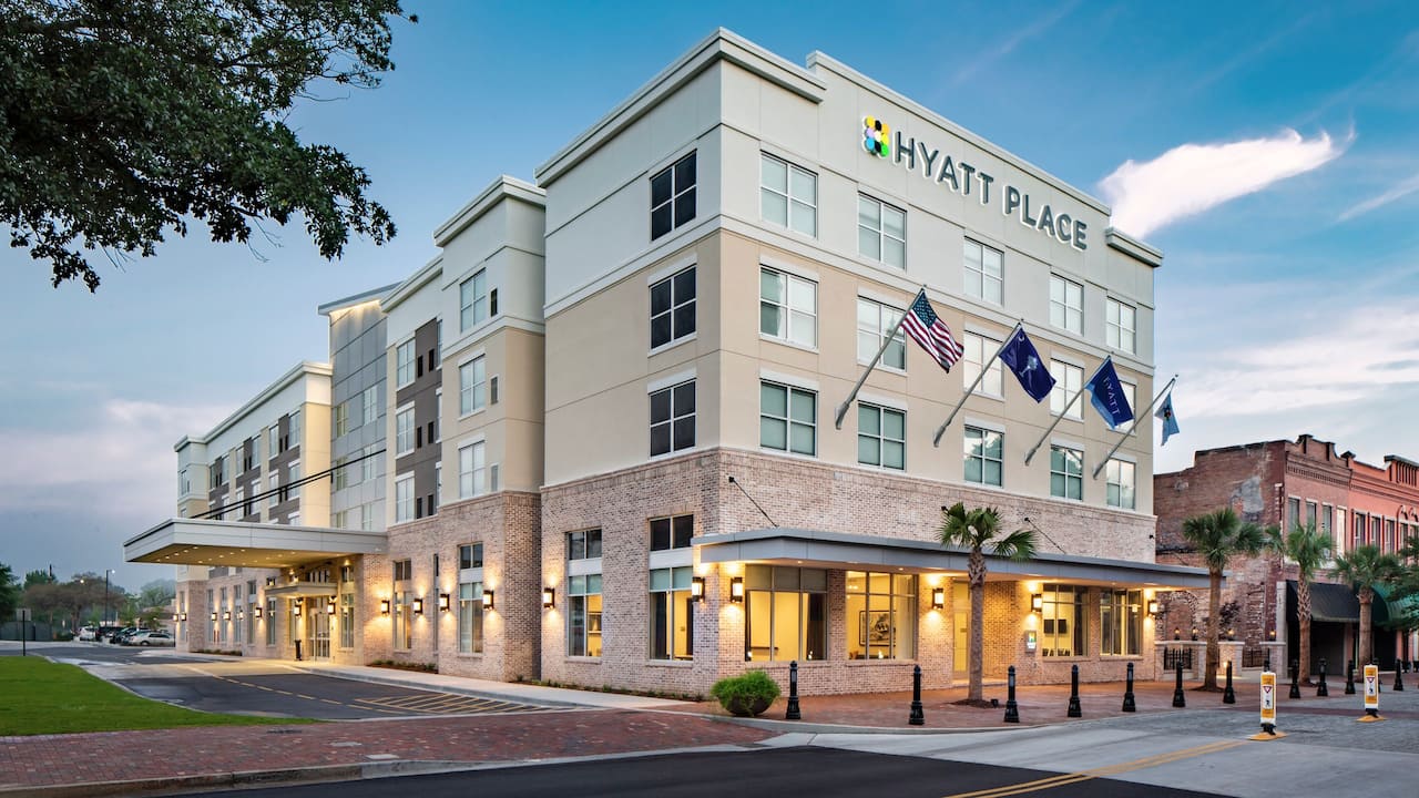 Hotel exterior with flags flying at twilight