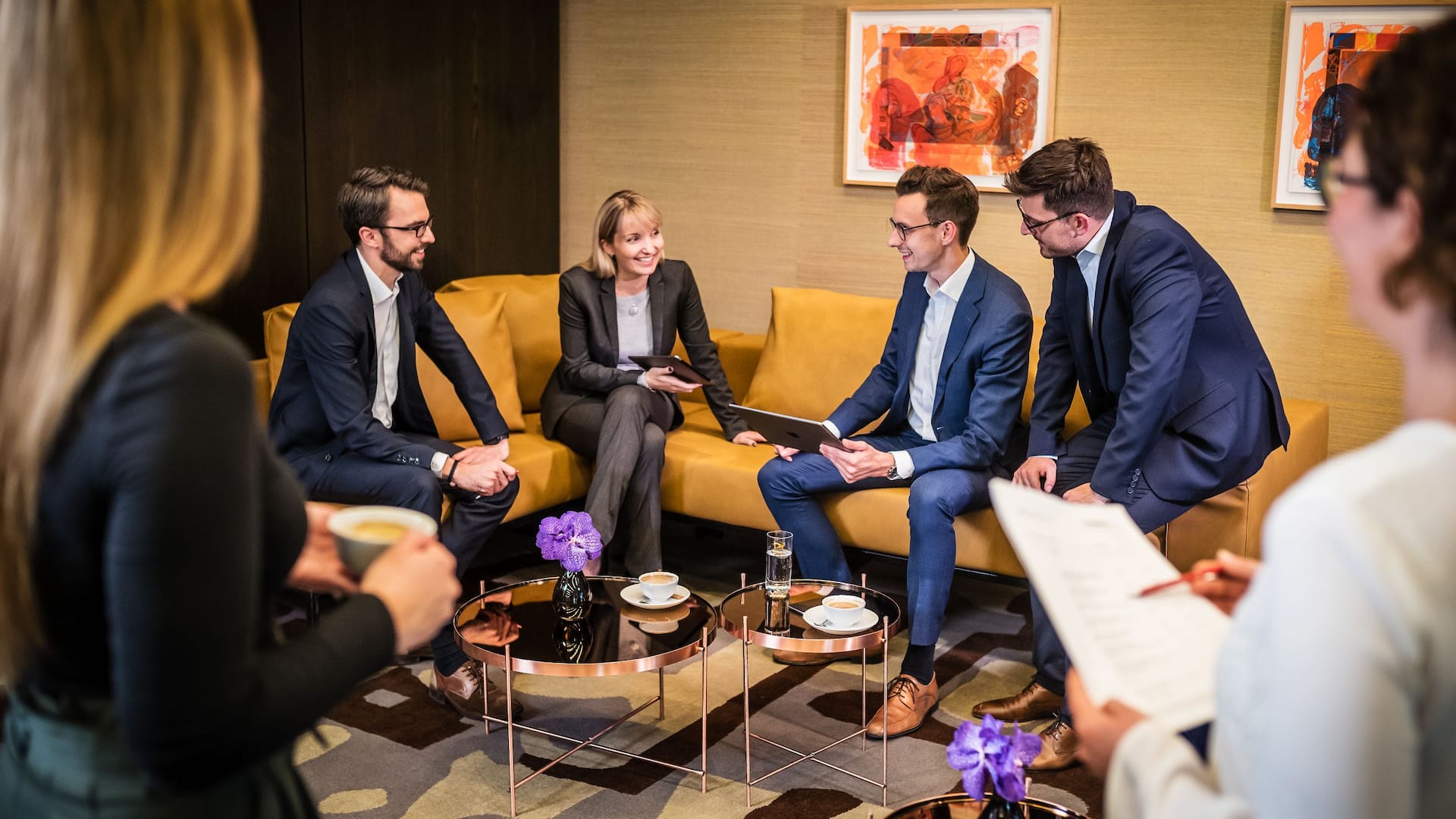 Meeting participants sit on the couch and have an animated conversation during a coffee break at Grand Hyatt Berlin