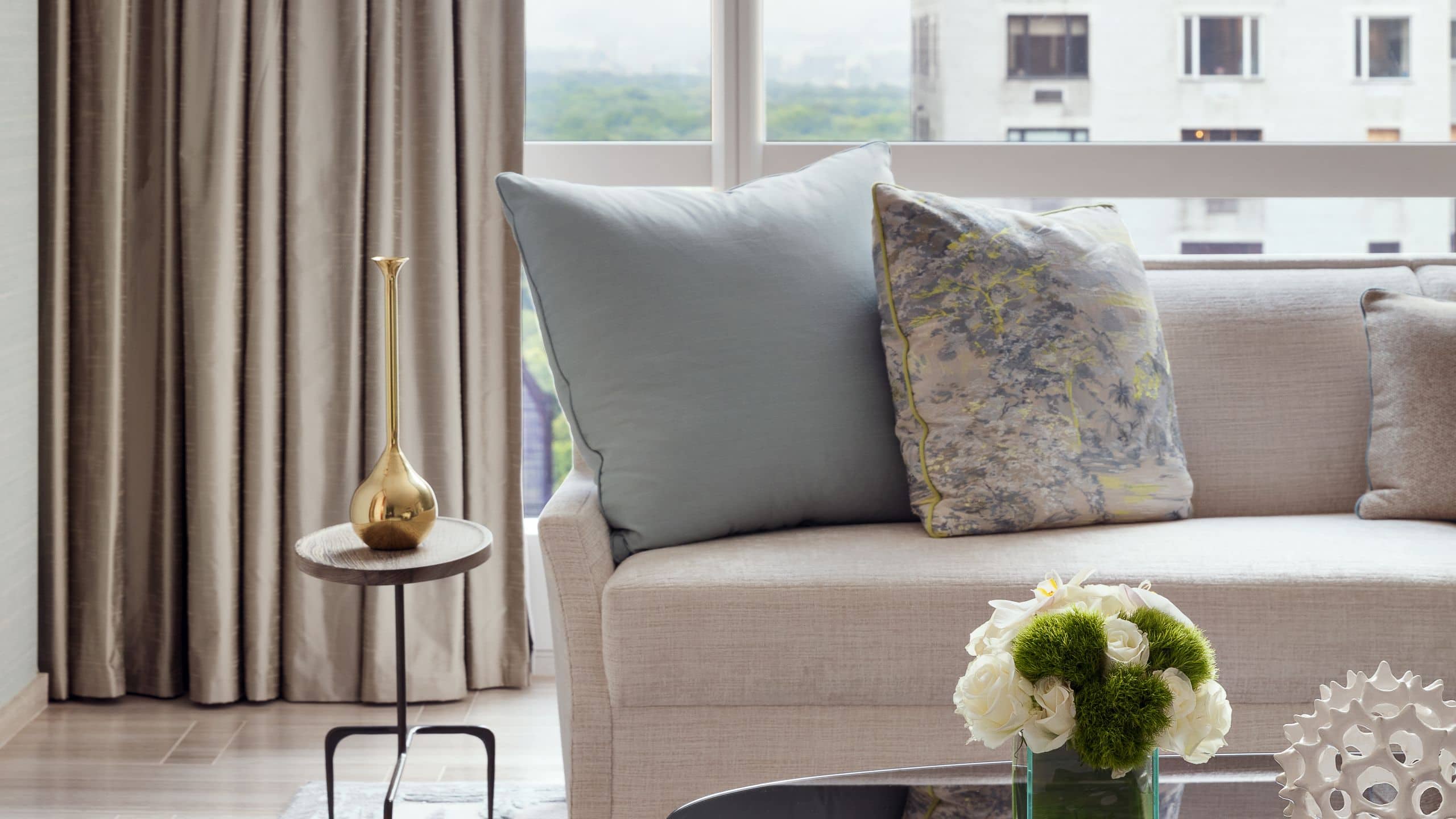 7 of 8 Large window showing city views and a large grey couch