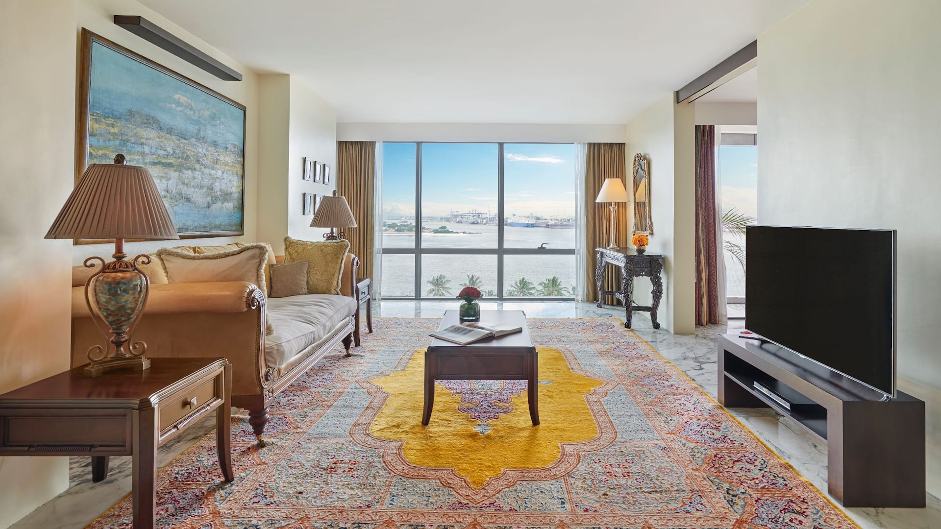 Presidential Suite lounge area, featuring comfortable sofas, a rich-colored carpet, and stunning ocean views.