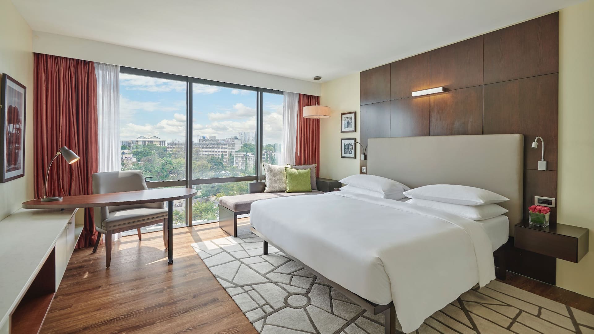 Regency Executive Suite featuring a spacious bed, patterned carpet and views overlooking the city.