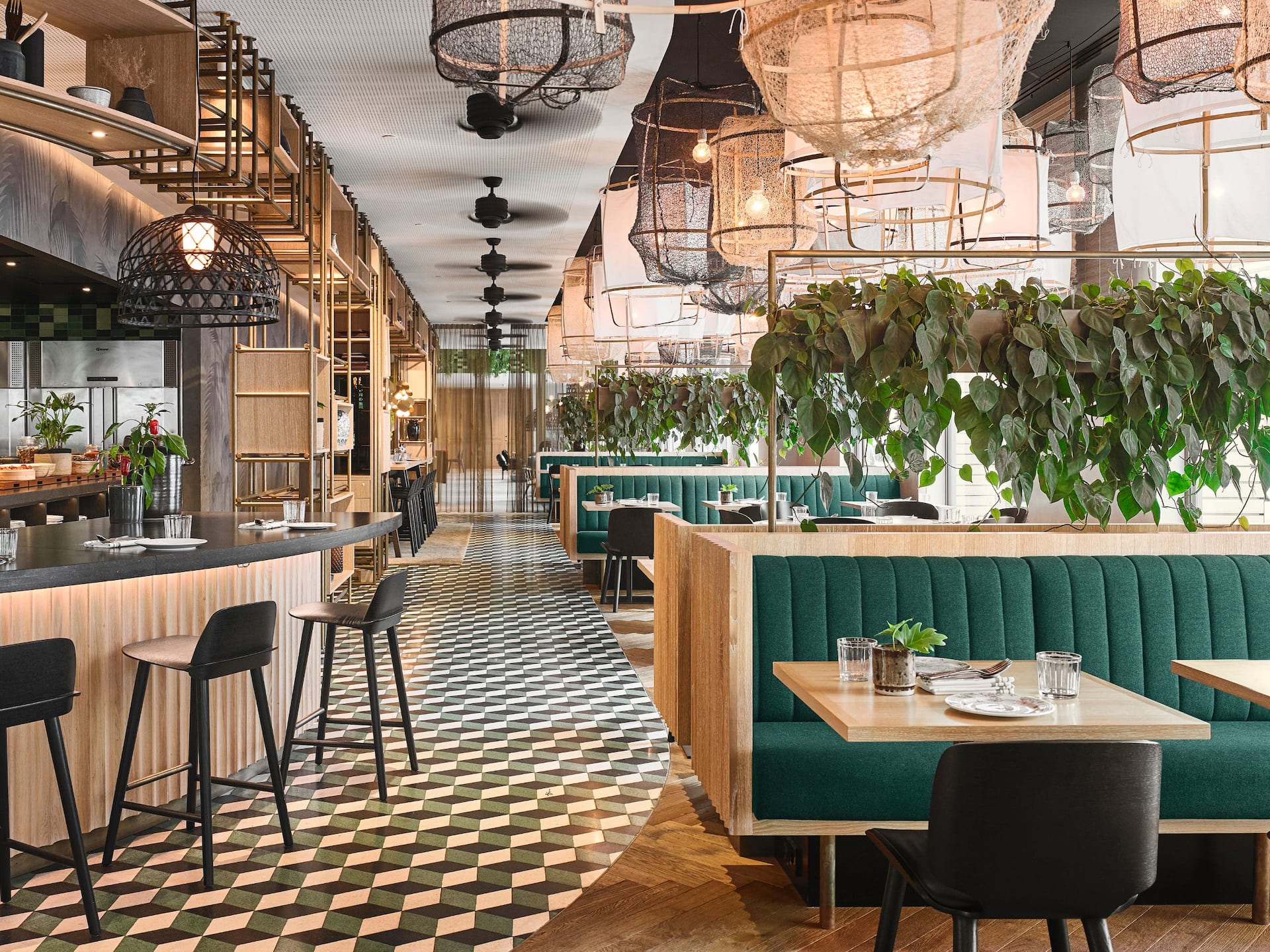 An overview of the greenery interior of restaurant Mama Makan, showcasing a stylish layout with tables and chairs.