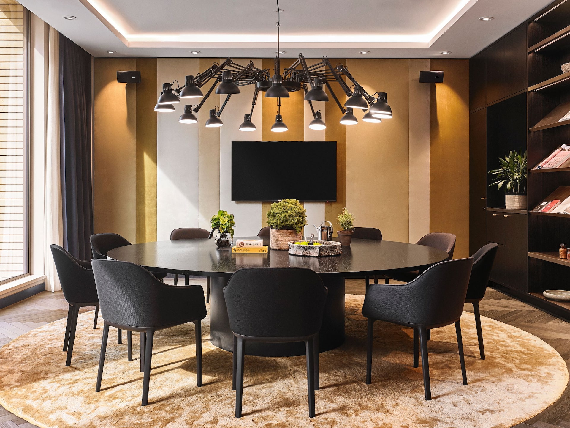 An overview of a meeting space Hyatt Regency Asmsterdam, showcasing a set up with a dark round table surrounded by chairs.