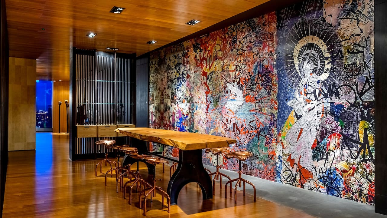 Ushin Reception area with large wood tabletop and art murals on the wall 