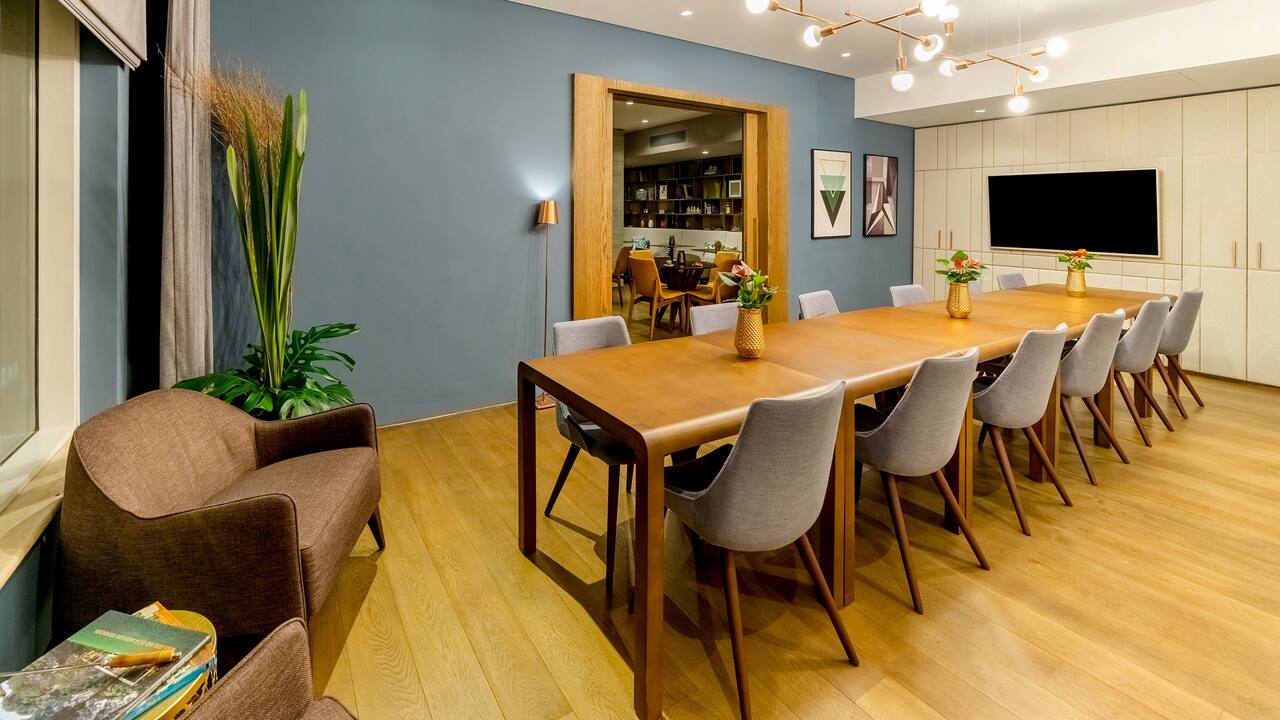 Grand Club conference room with HDTV, communal table and wall-mounted HDTV