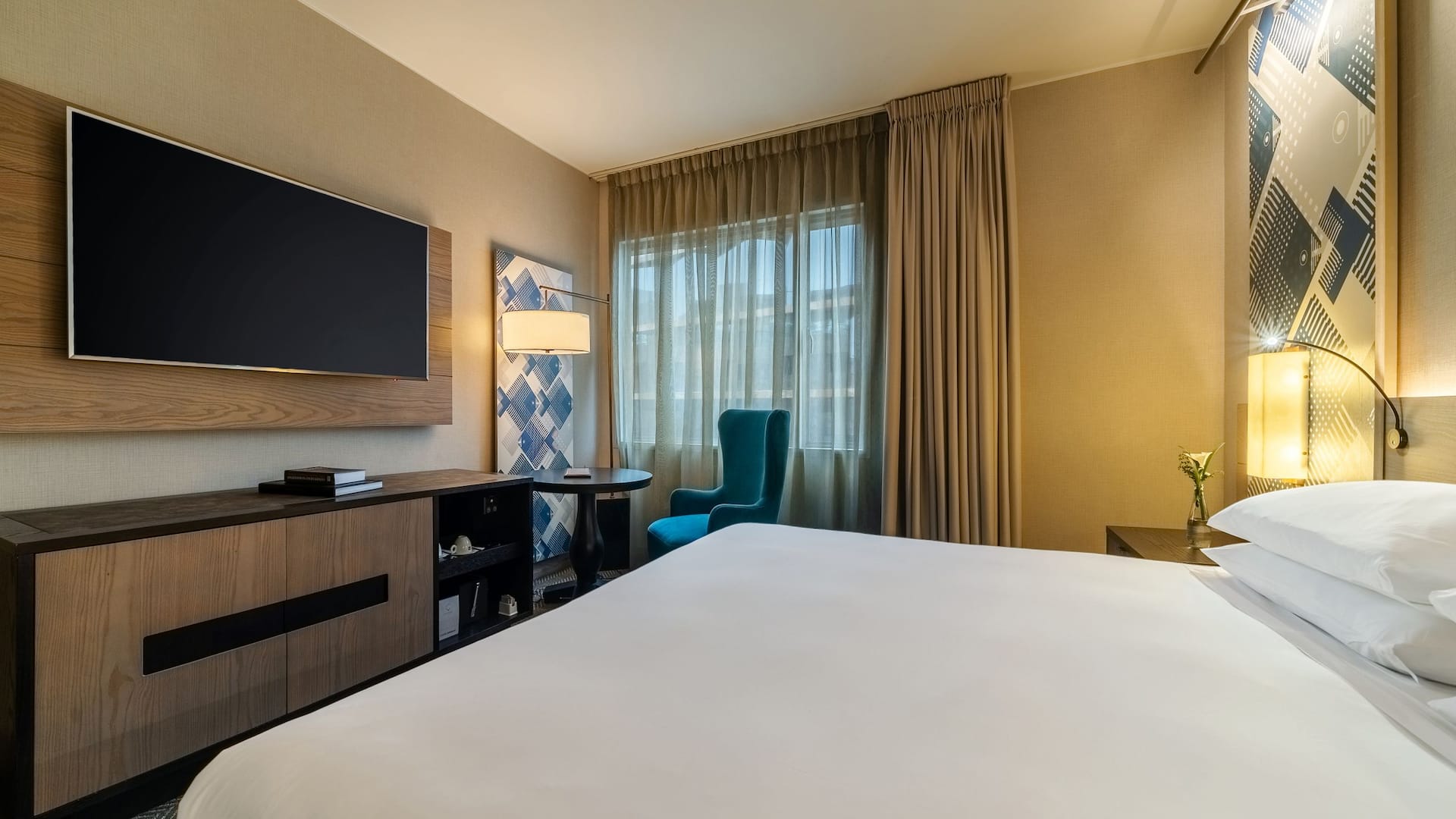 1 de 1 One King Bed guest room with wall mounted television, small work table and reading chair