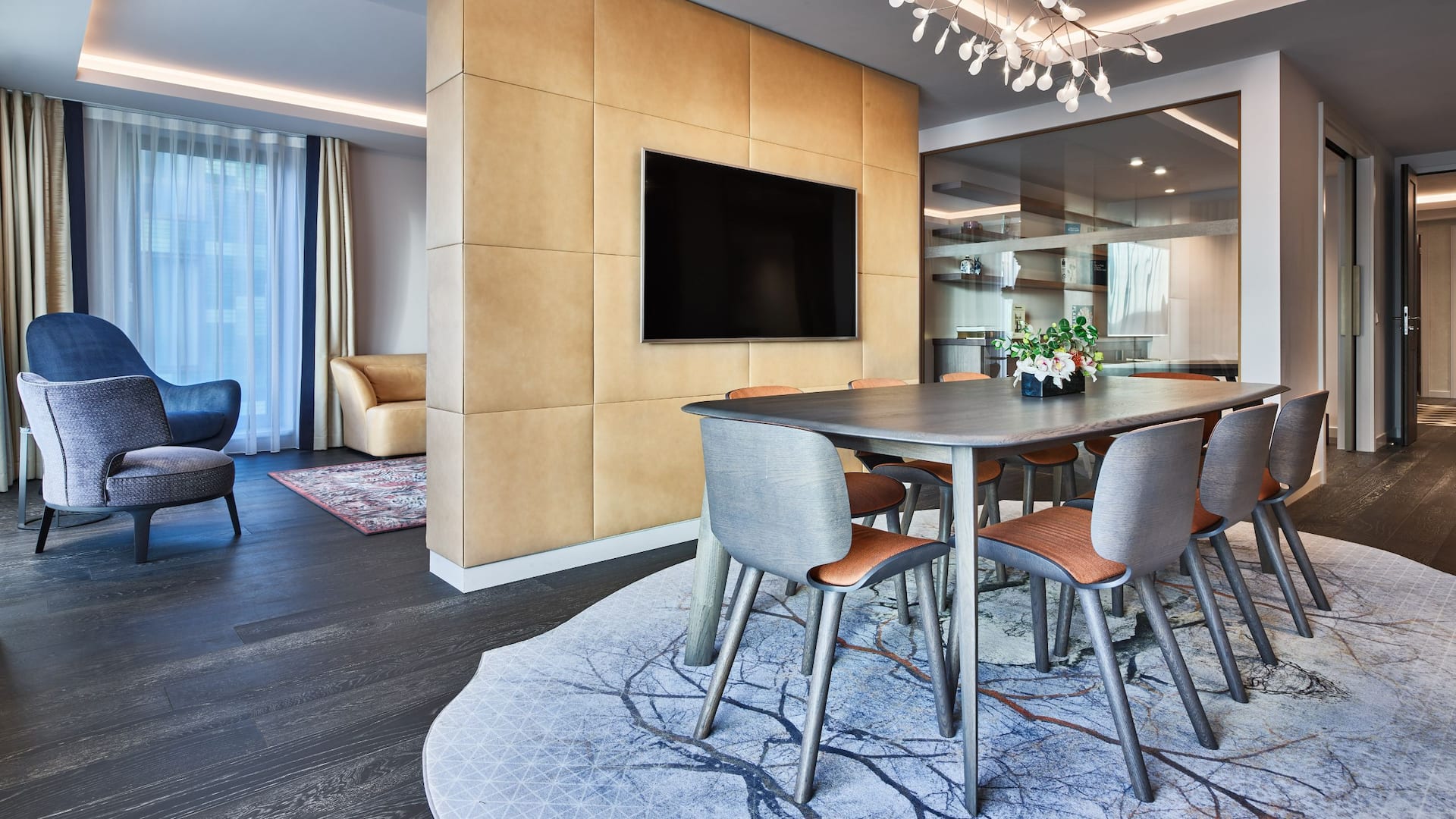 The dining area of the Spinoza Suite at Hyatt Regency Amsterdam, with a TV, table, and a glimpse to the living area.