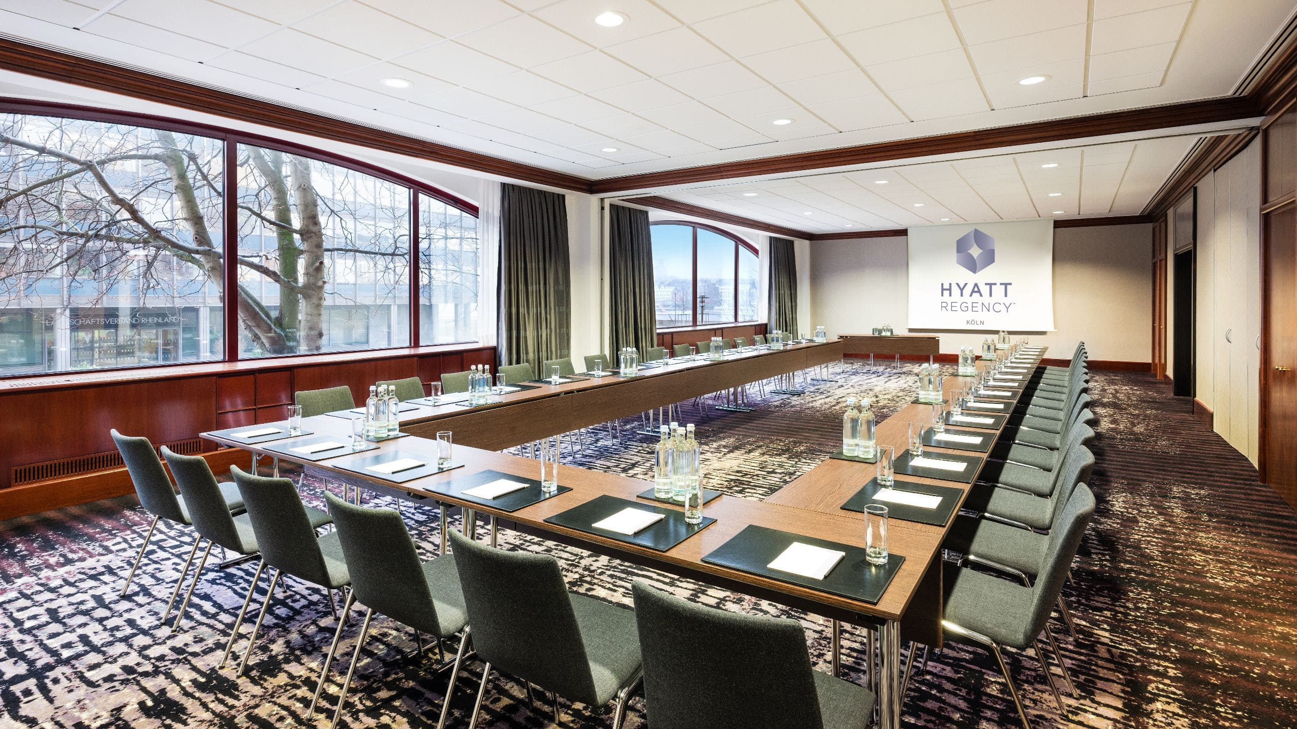 Meeting room with natural daylight and modern U-shaped seating at the Hyatt Regency Cologne