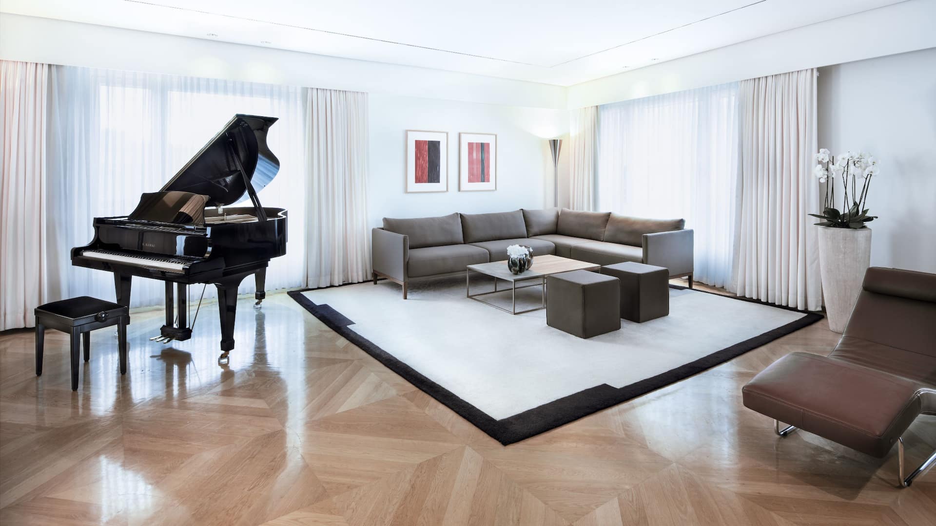 Ein atemberaubender Blick in das Wohnzimmer der Maybach Suite im Grand Hyatt Berlin, ausgestattet mit einem eleganten Flügel und einer stilvollen Sitzecke.