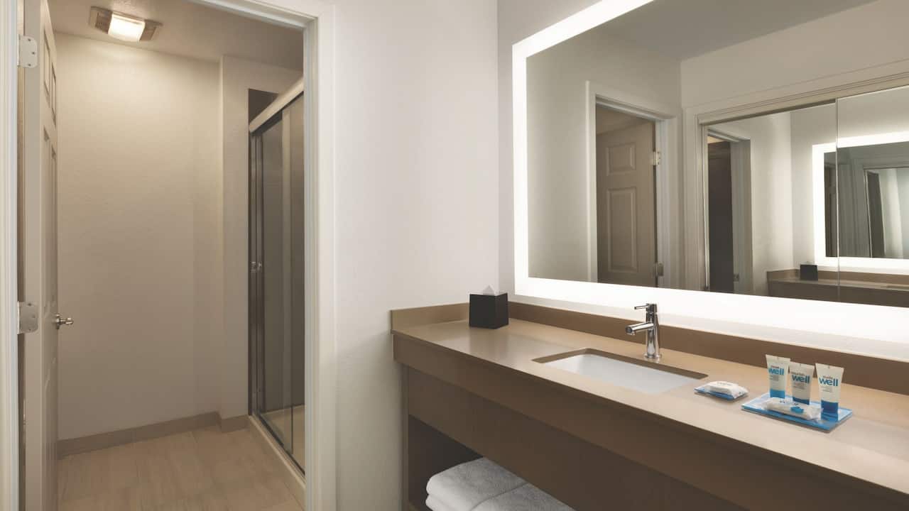 Guest room bathroom sink and mirror with walk in shower at Hyatt House Boston / Burlington