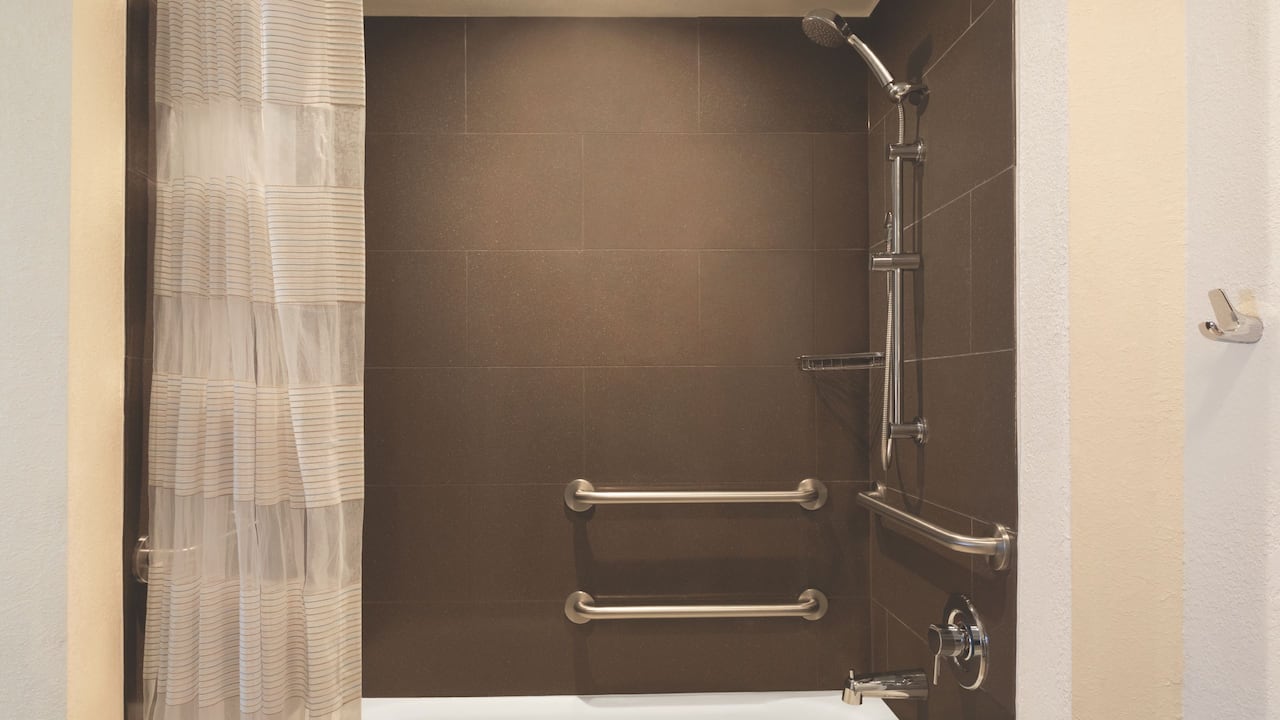 Accessible bath/shower combo with bath seat and grab rails at Hyatt House Boston / Burlington