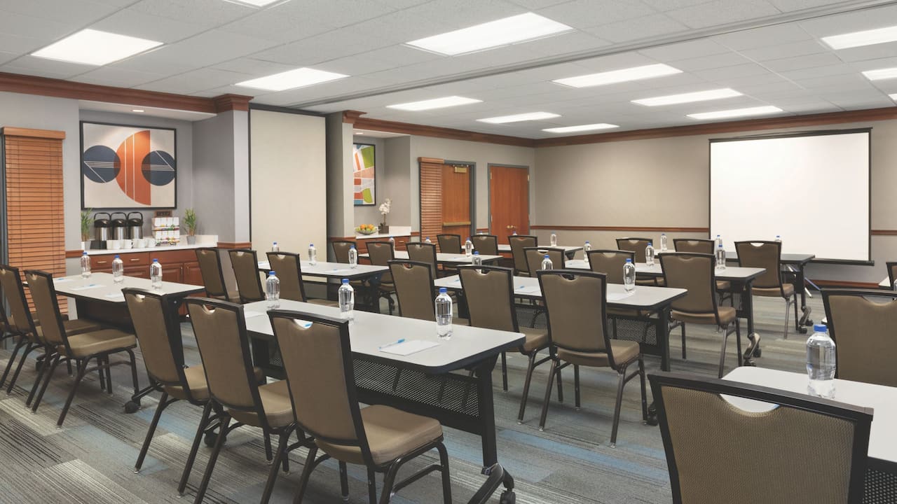 Meeting space near Boston set up in classroom shape with projector and coffee bar at Hyatt House Boston / Burlington