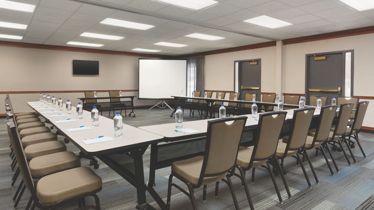 Meeting space near Boston set up in u-shape with projector and panel seating at Hyatt House Boston / Burlington