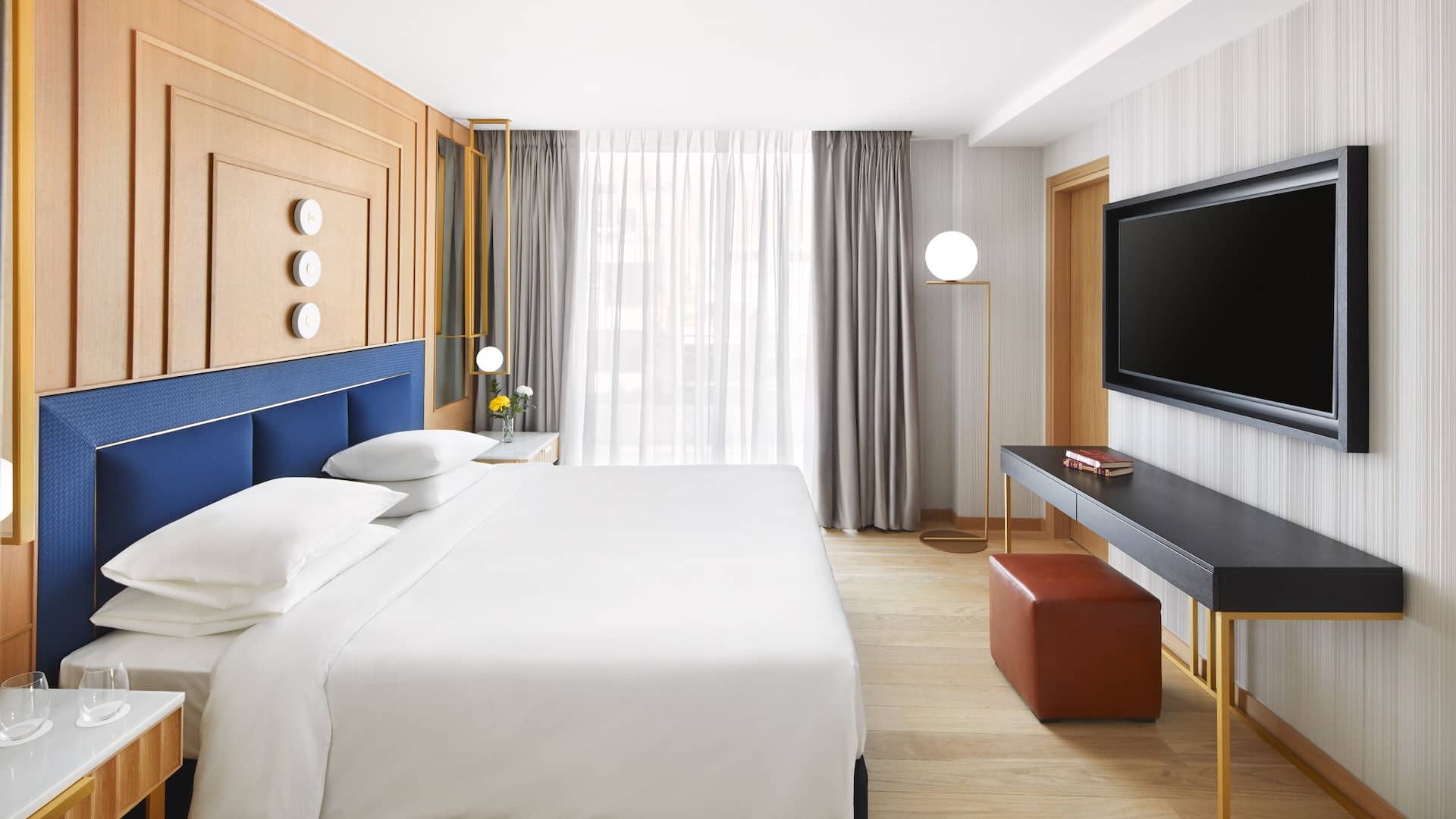 Bedroom of Grand Suite at Grand Hyatt, a luxury hotel in Athens near Acropolis, that blends earthy & royal blue tones.