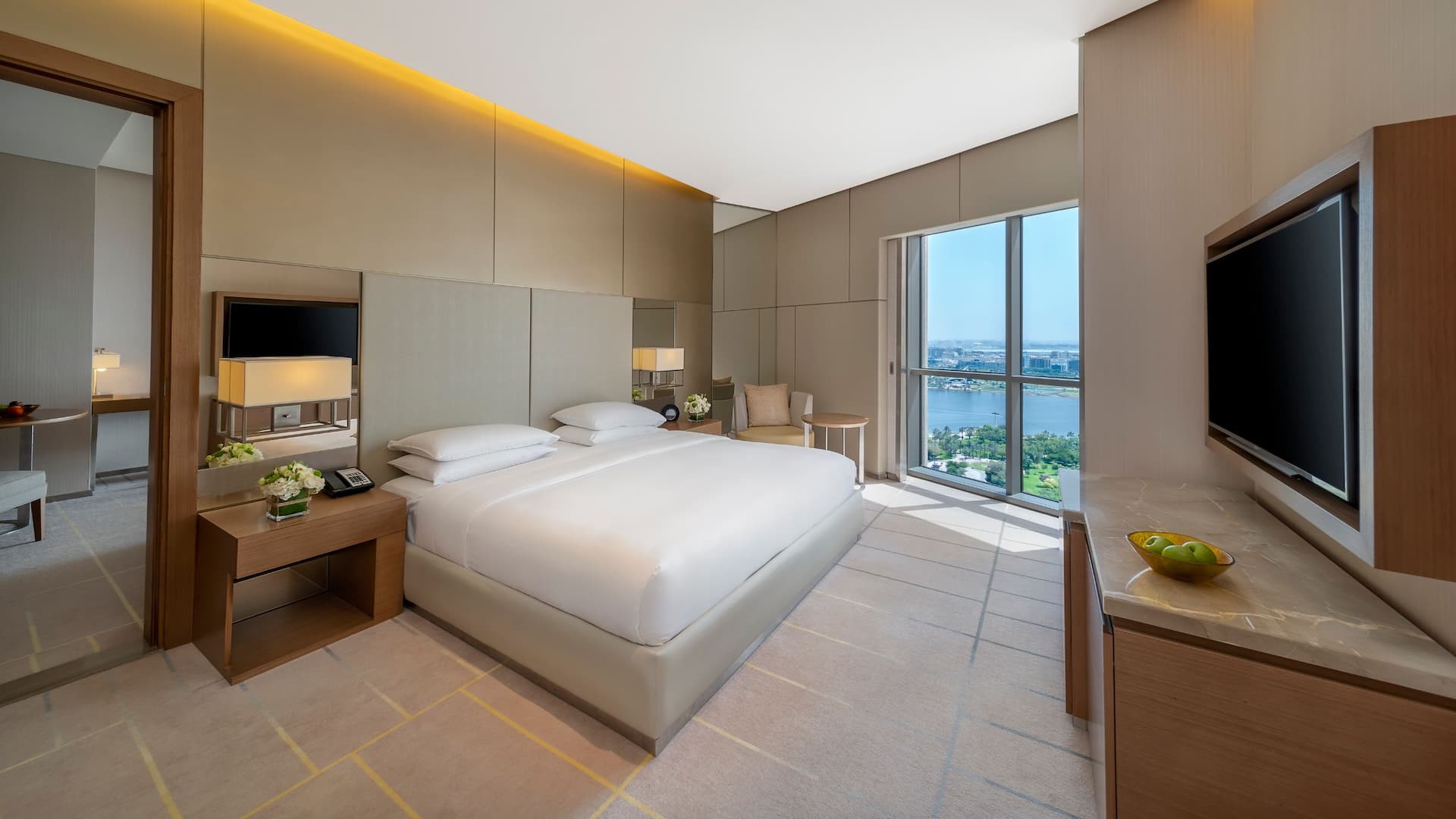 View of Emiri Suite with a king bed, a separate living area, and view of Dubai Creek.