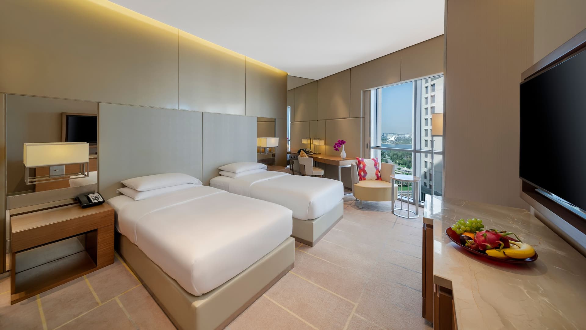1 of 5 A room with two twin beds, a working area and TV amenity at Hyatt Regency Dubai Creek Heights.