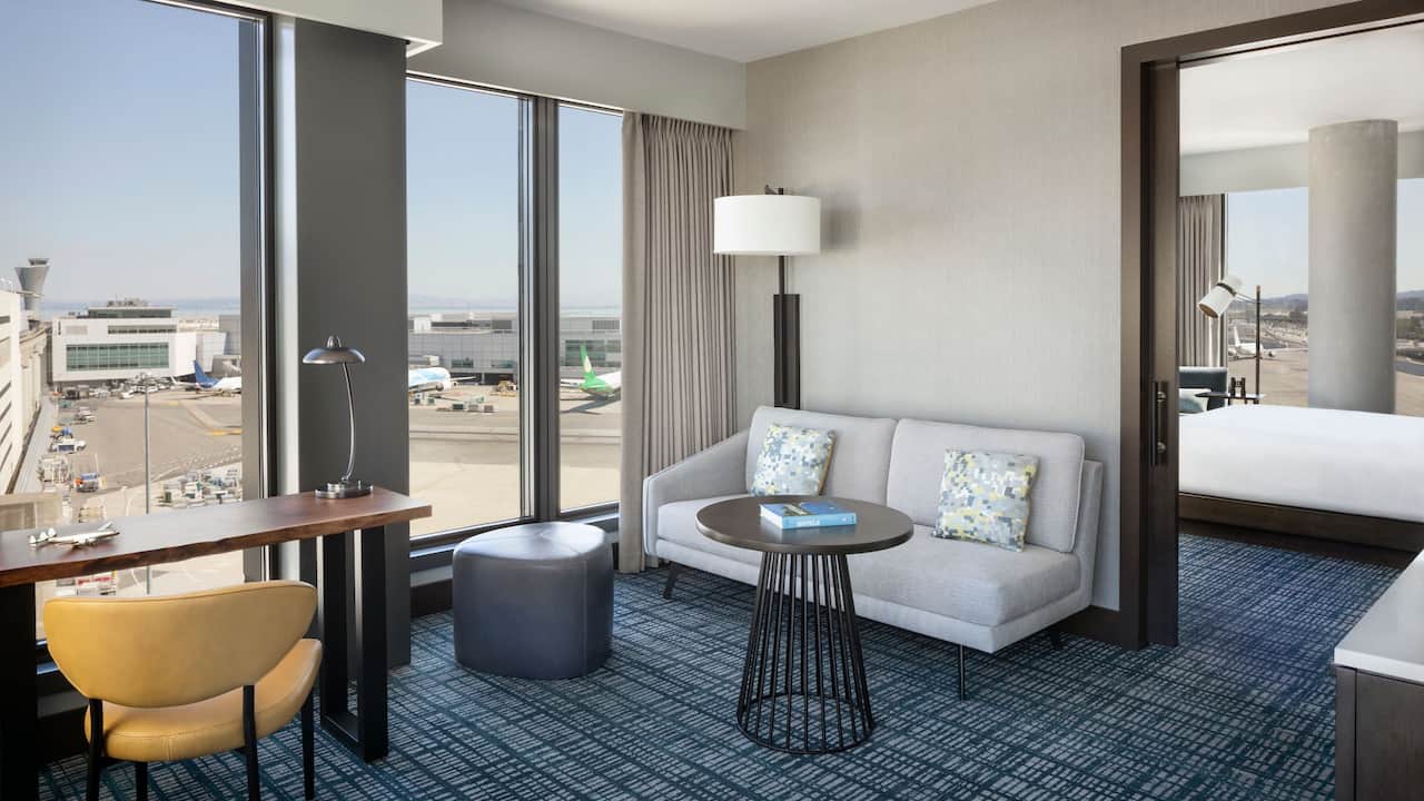 Corner Suite living space with couch, desk, and floor-to-ceiling windows