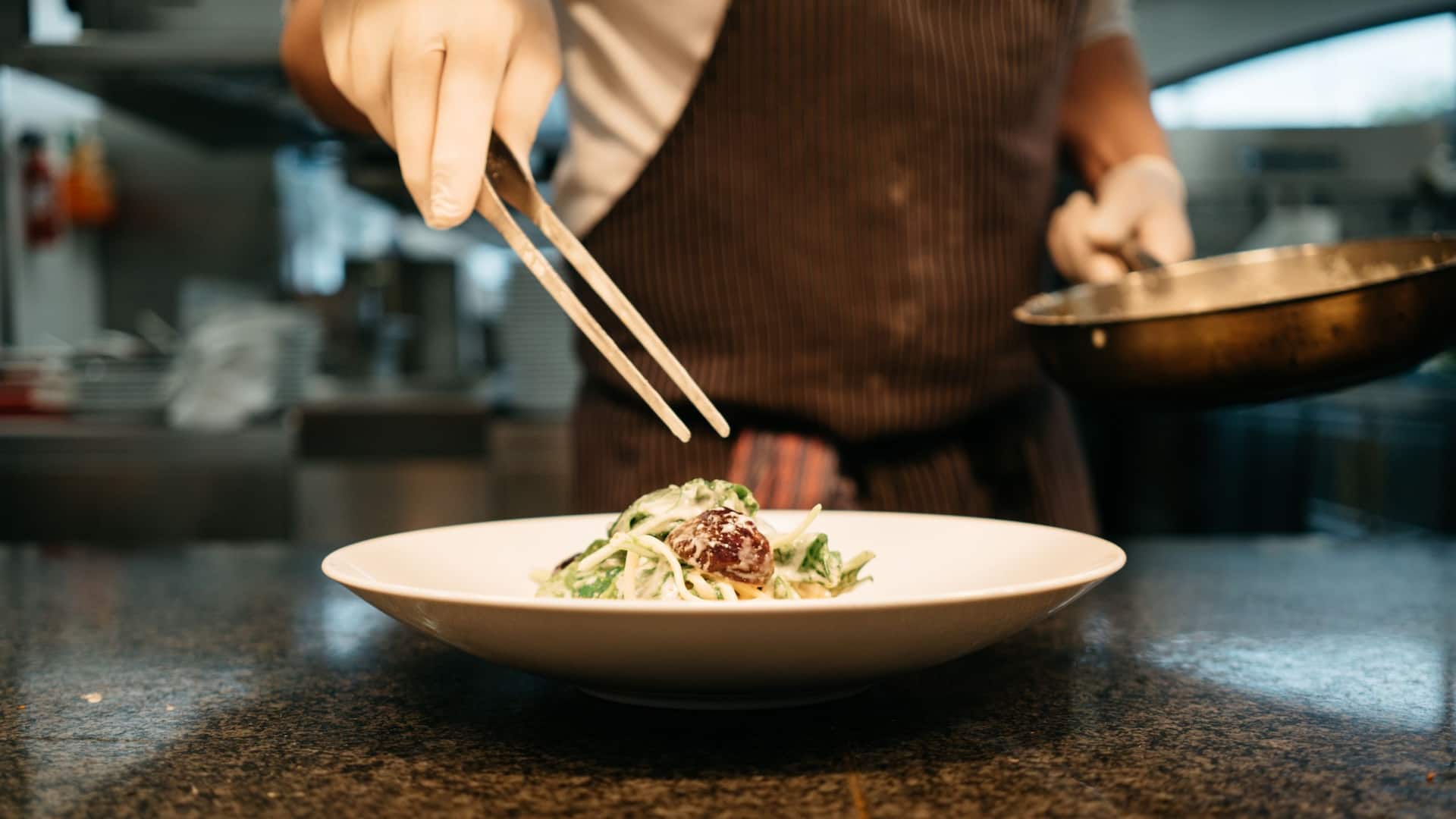 Chef at Glashaus Restaurant of Hyatt Regency Cologne prepares plates