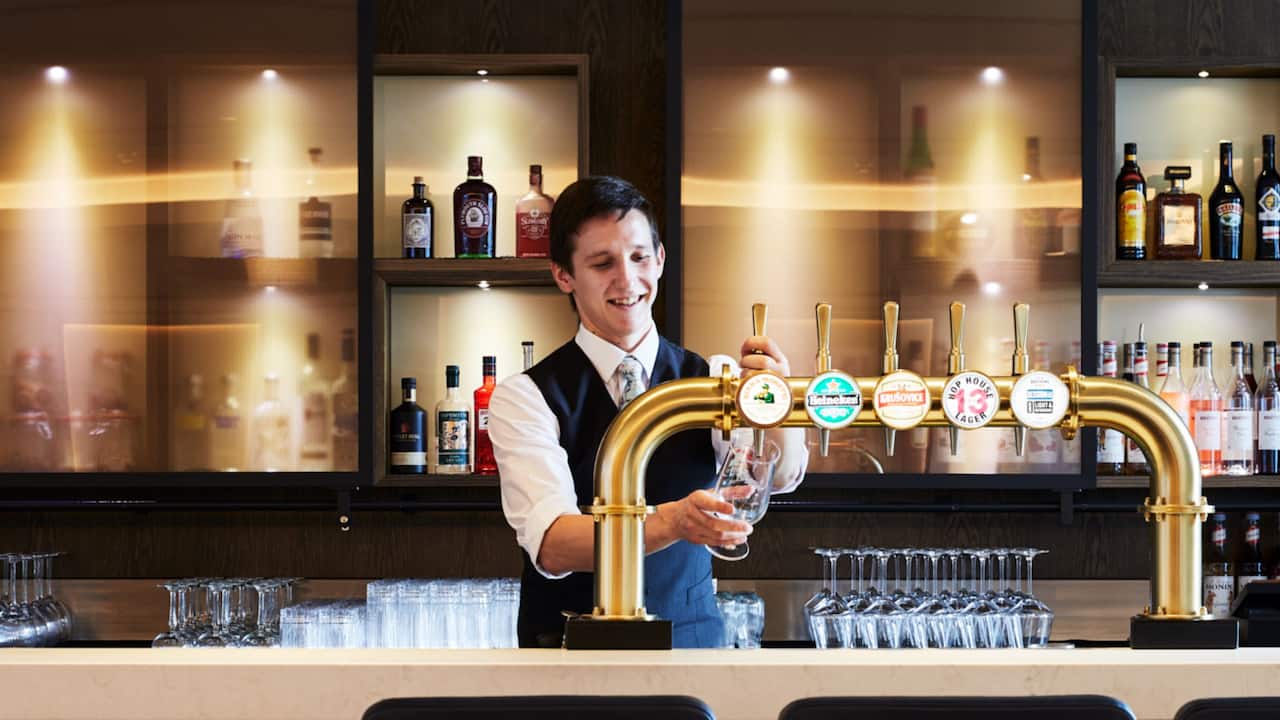 A bartender pouring beer at The Graduate Bar