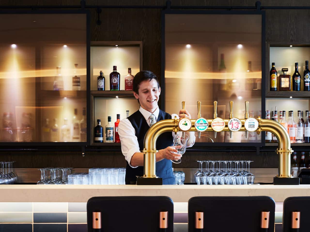 A bartender pouring beer at The Graduate Bar