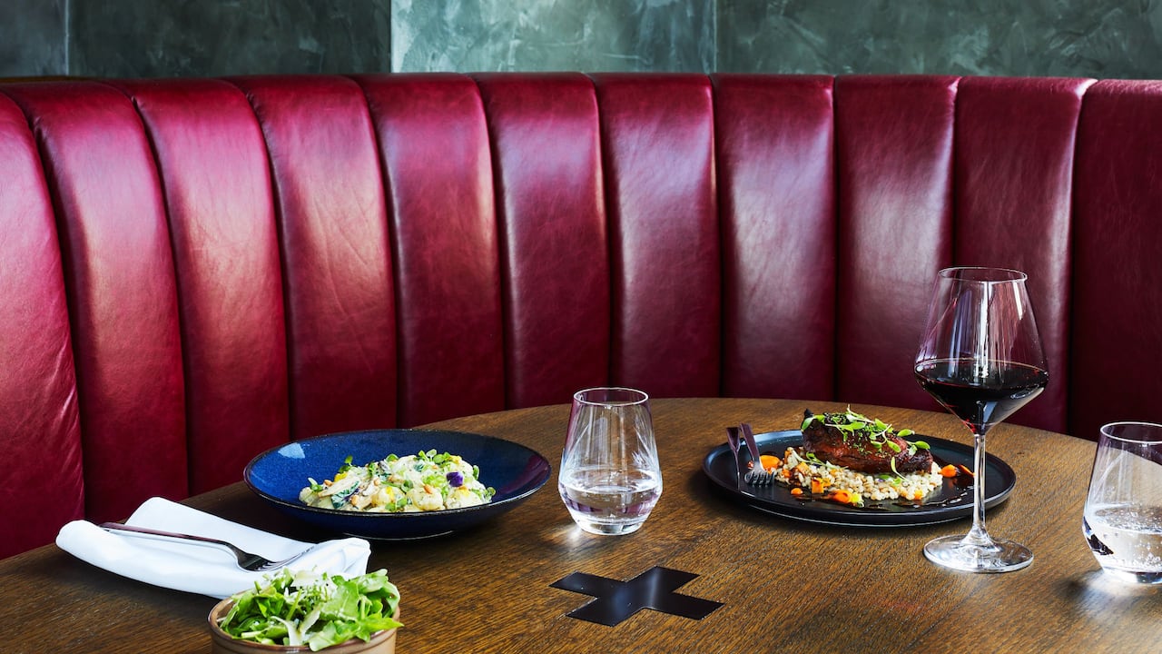 The Laureate restaurant table with dishes and red wine