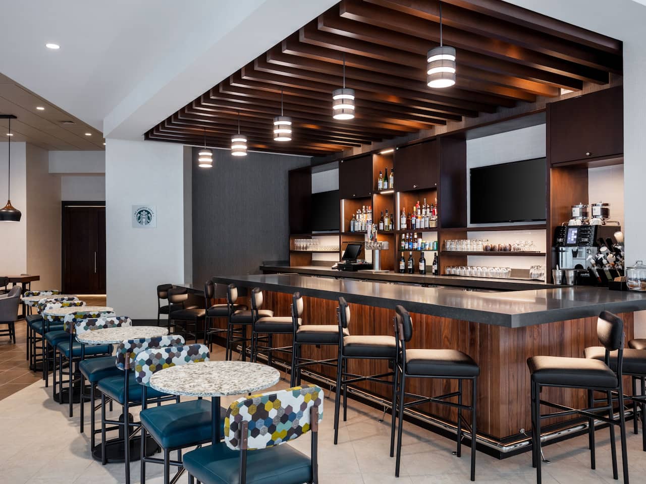 The Bar with flat-screen televisions, bar seating and tables at Hyatt Place Atlanta/Centennial Park