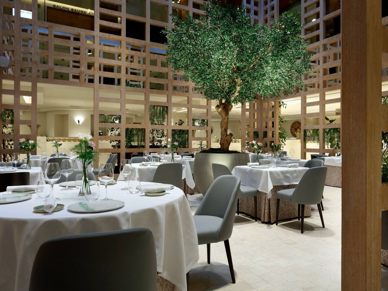 Mesas del restaurante La Manzana iluminadas por la luz natural en nuestro hotel Hyatt Regency Hesperia Madrid.