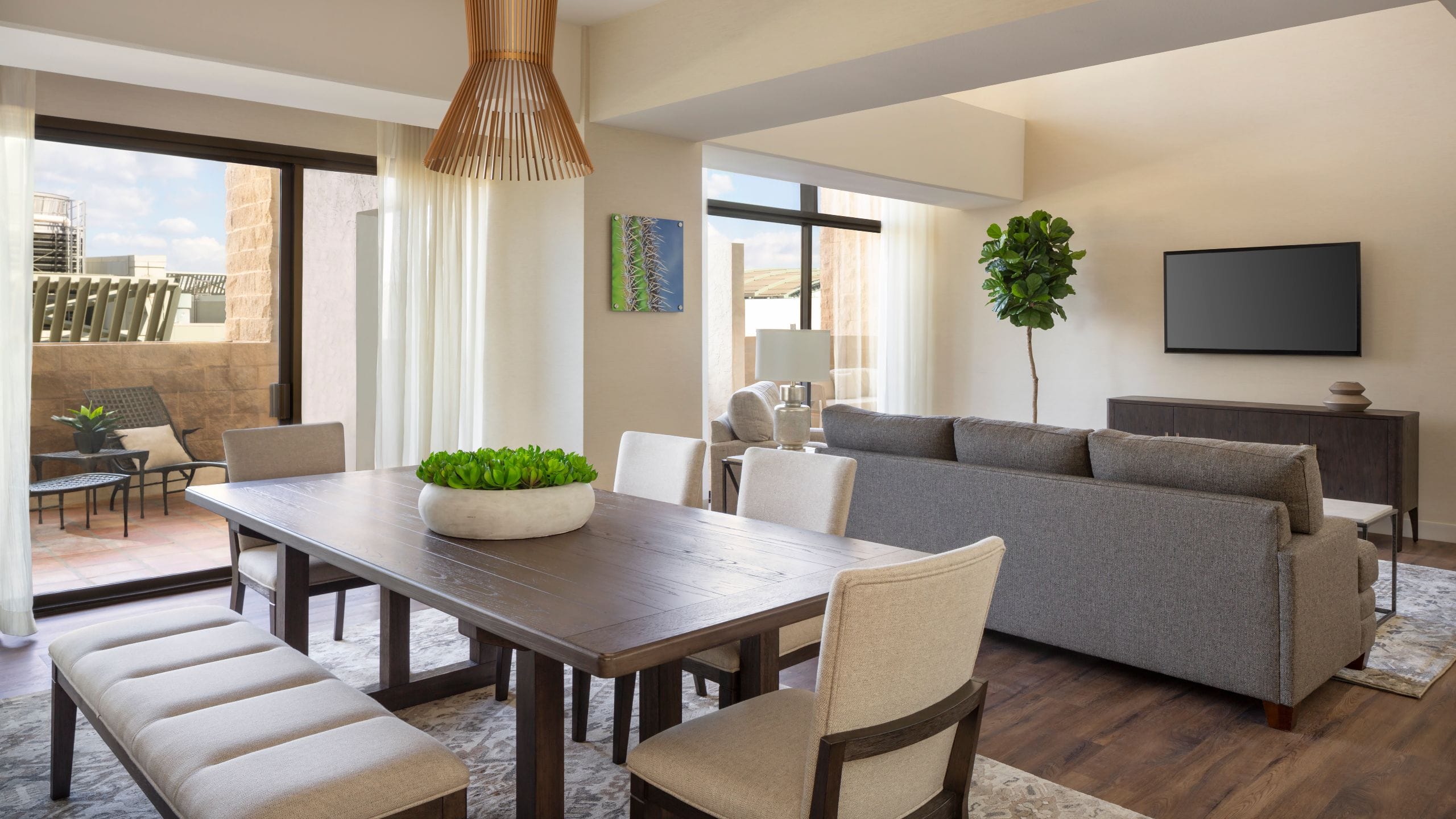 A living room and dining area with a balcony from a hotel suite in downtown Phoenix
