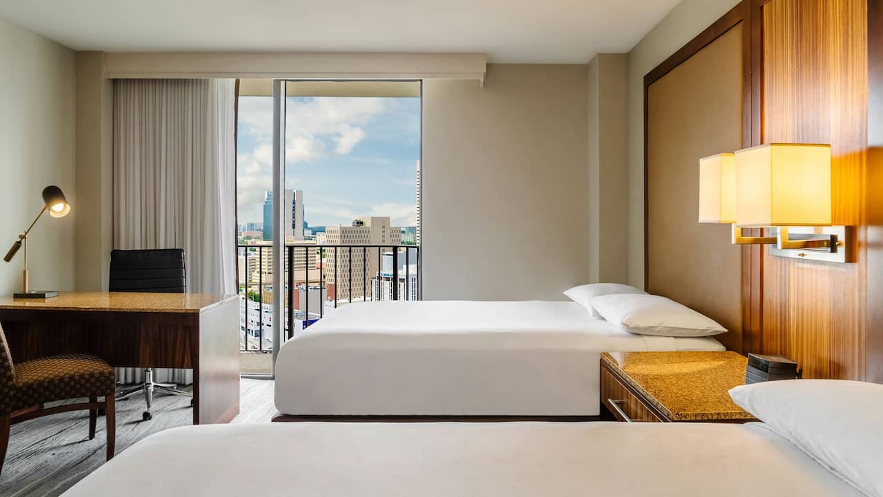 Two Double Beds guest room with desk and city view