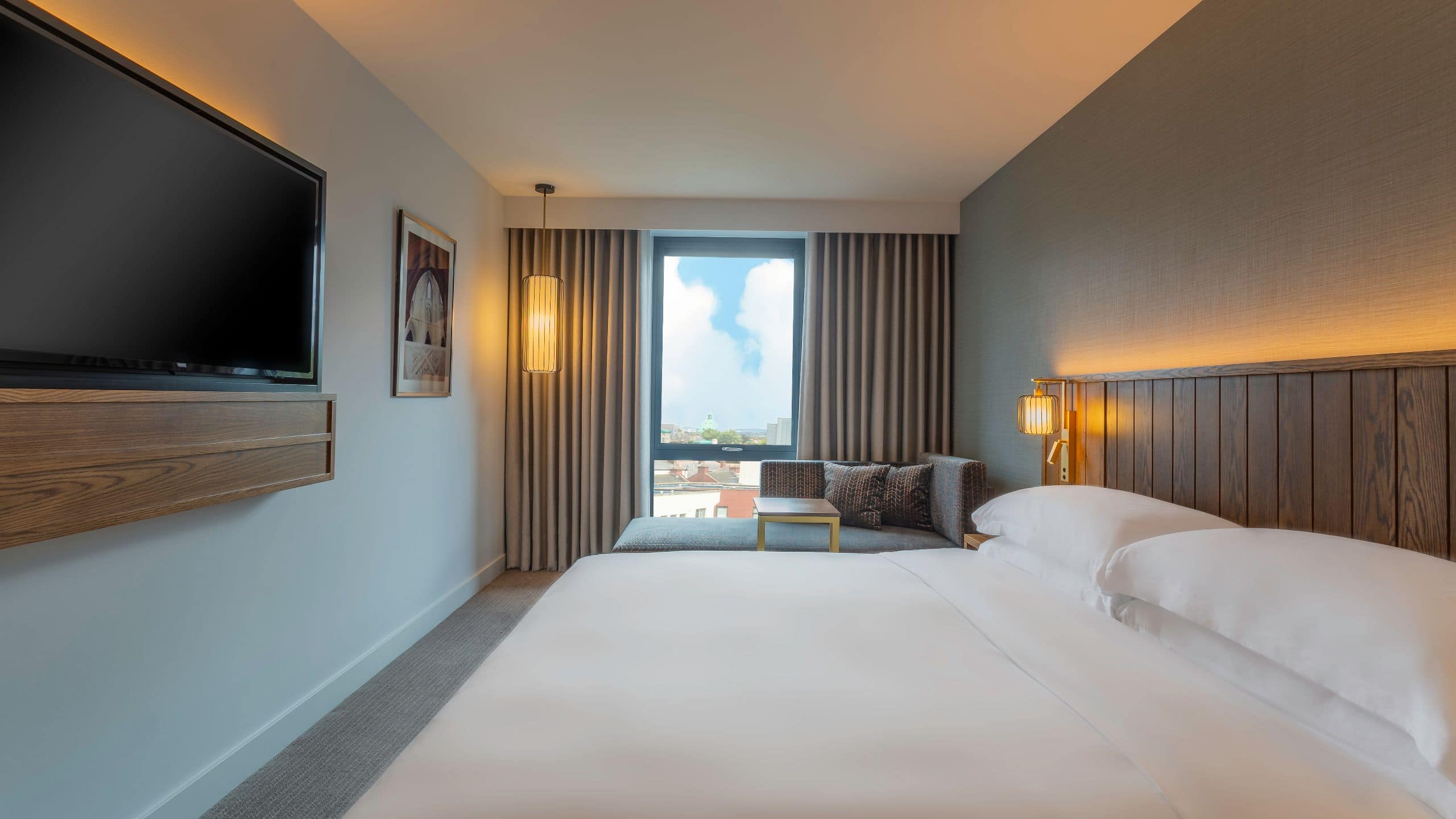 1 of 1 A cosy hotel room here in Dublin city near the Guinness storehouse with a large bed, sofa, neutral tones and a grey rug