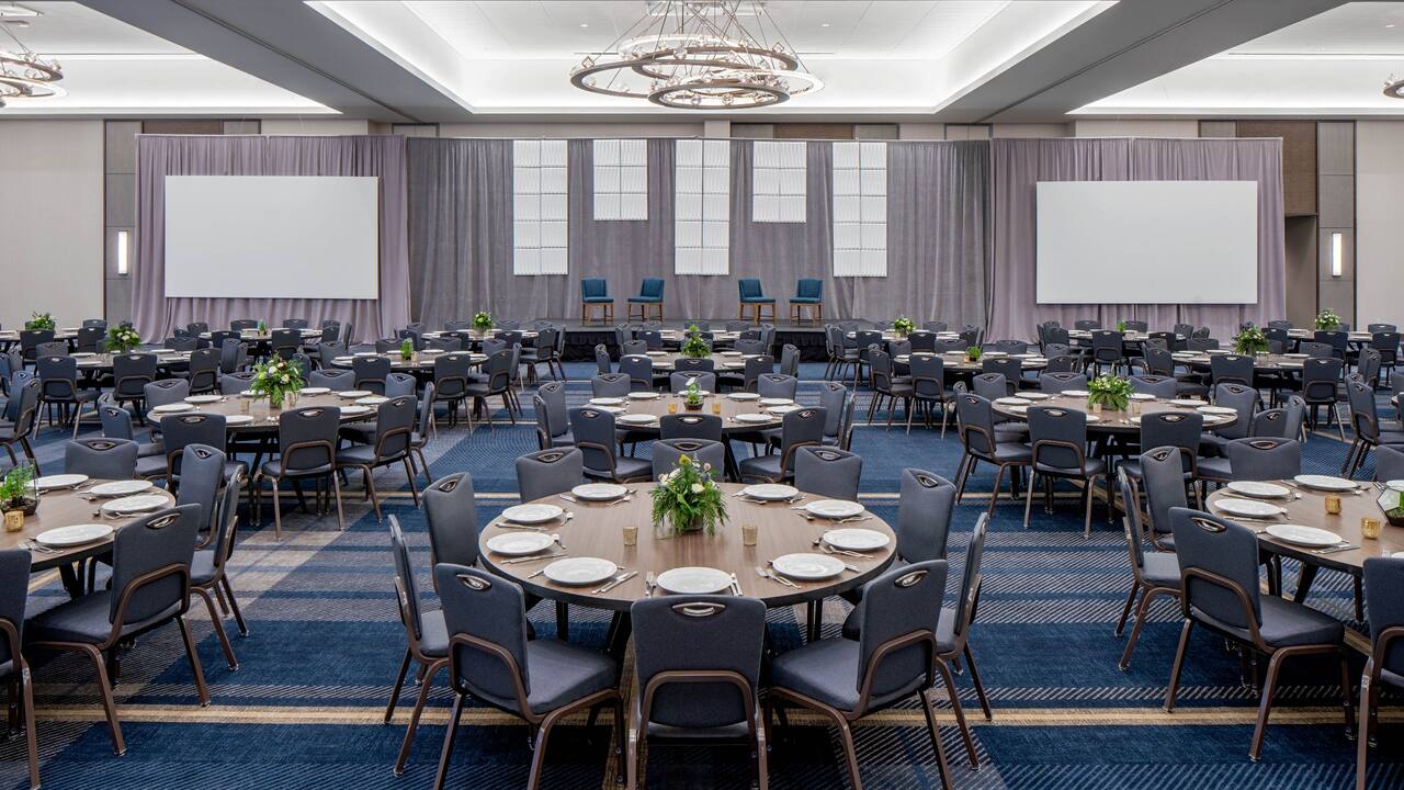 Large meeting room, Regency Ballroom, banquet setup with stage and projectors