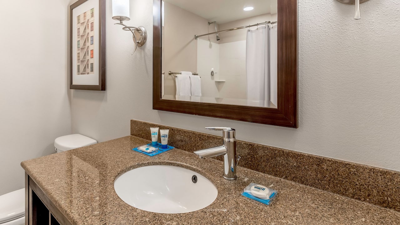 Guest room bathroom sink and mirror with tub and shower combo at Hyatt House Richmond / Short Pump