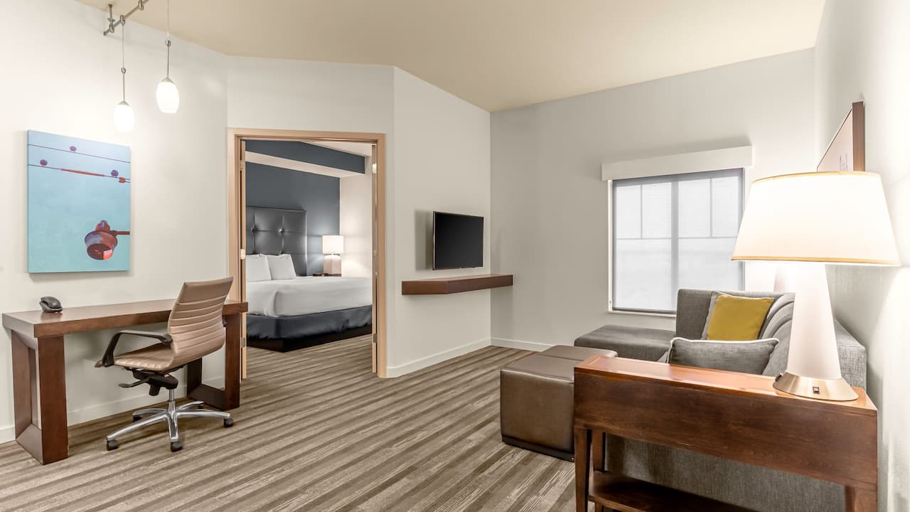 One bedroom king suite living area with sofa and tv and doorway to room at Hyatt House Richmond / Short Pump