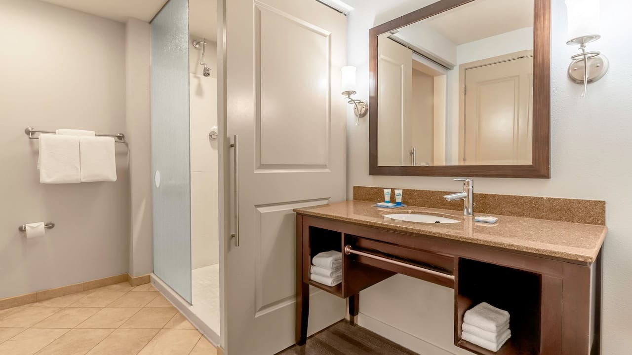 Guest room bathroom sink and mirror with walk in shower at Hyatt House Richmond / Short Pump