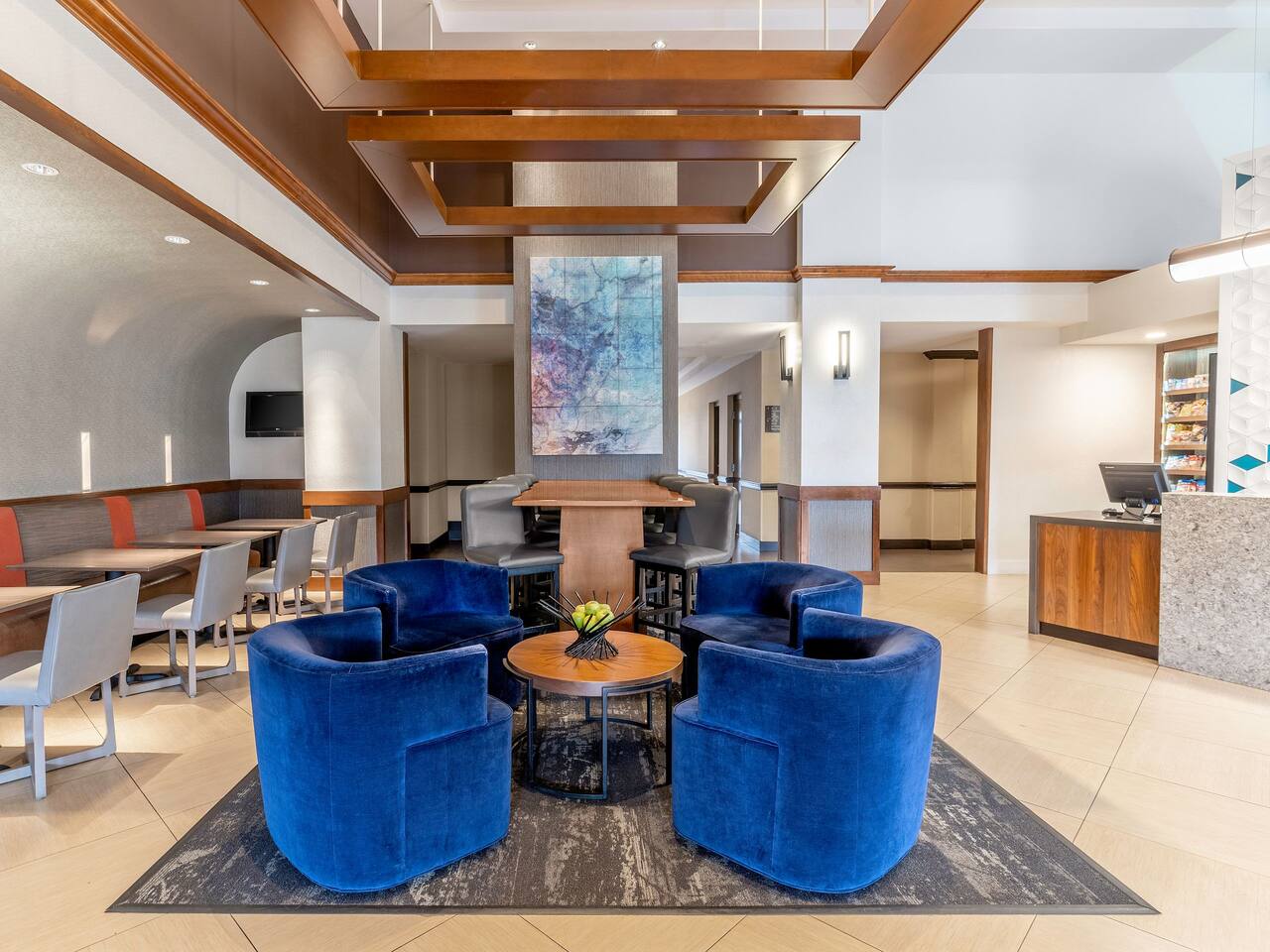 Lobby area with seating area and colorful painting on the wall.