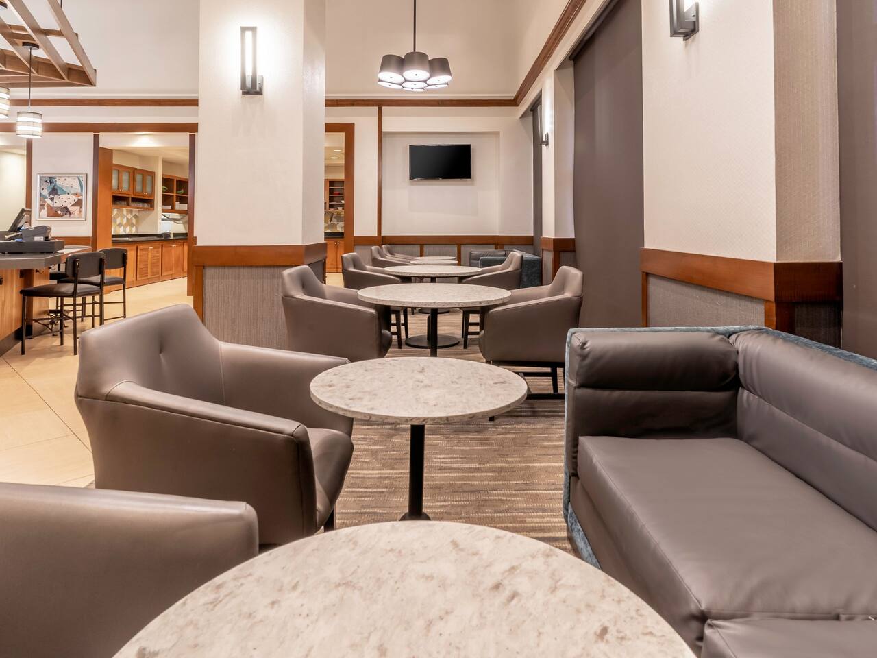 Lobby area with table seating and padded chairs.