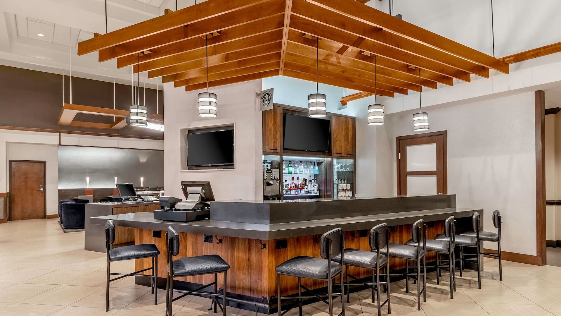 Bar area with bar stool seating and two televisions.