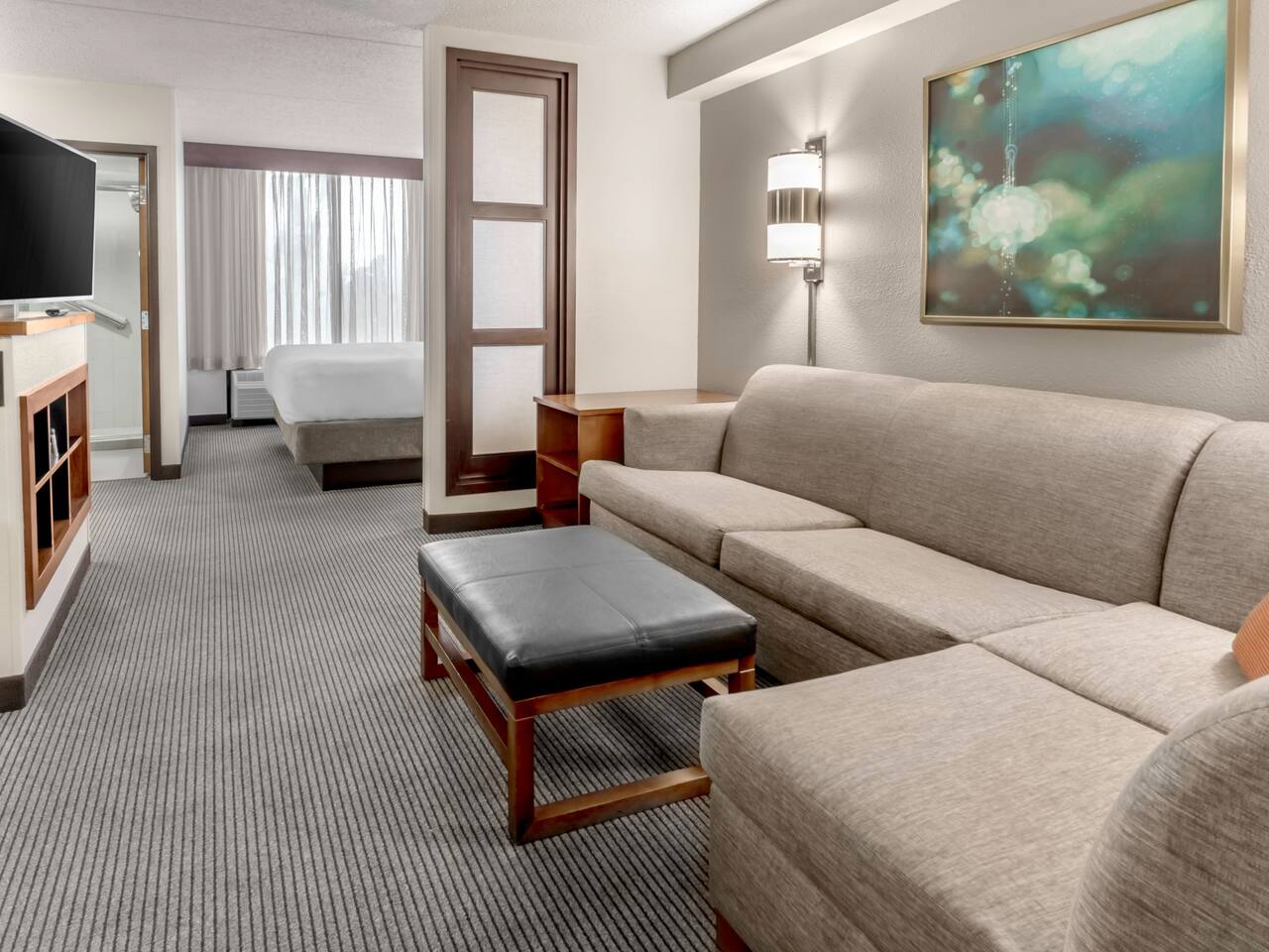 A King bed guestroom at our Charlotte Hyatt hotel with sleeper sofa in living room area