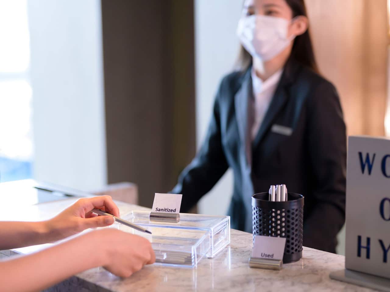 Sanitizing Front Desk Pen with Staff
