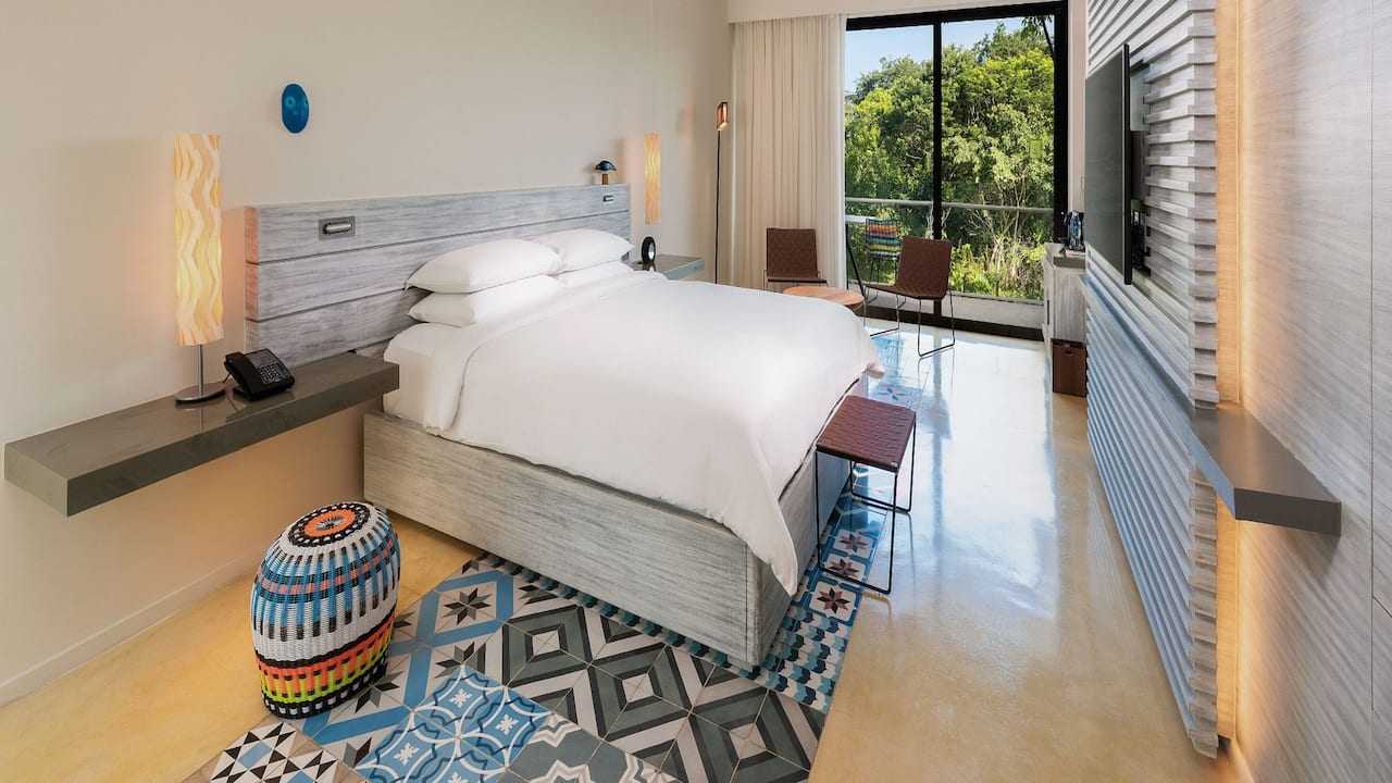 One king bed resort room with a balcony view of the lagoon at Andaz Mayakoba Resort Riviera Maya 