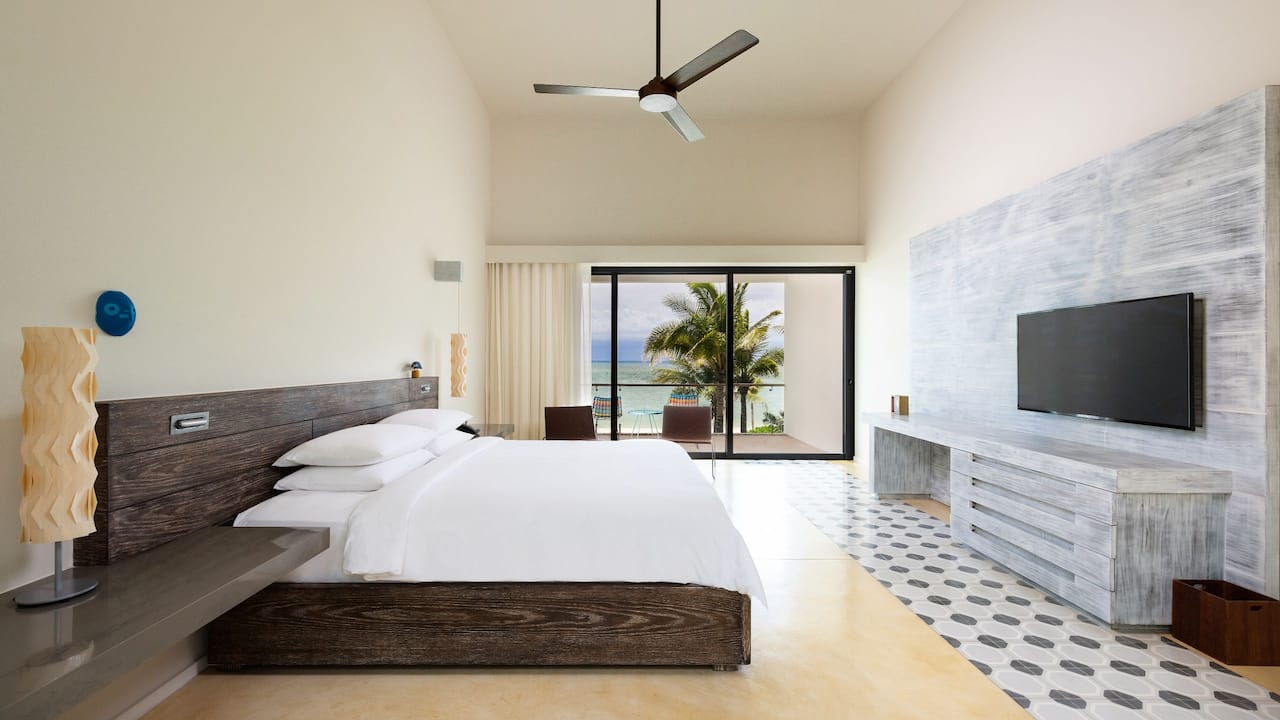 The bedroom view of a bi-level suite with a balcony view of the beach at Riviera Maya