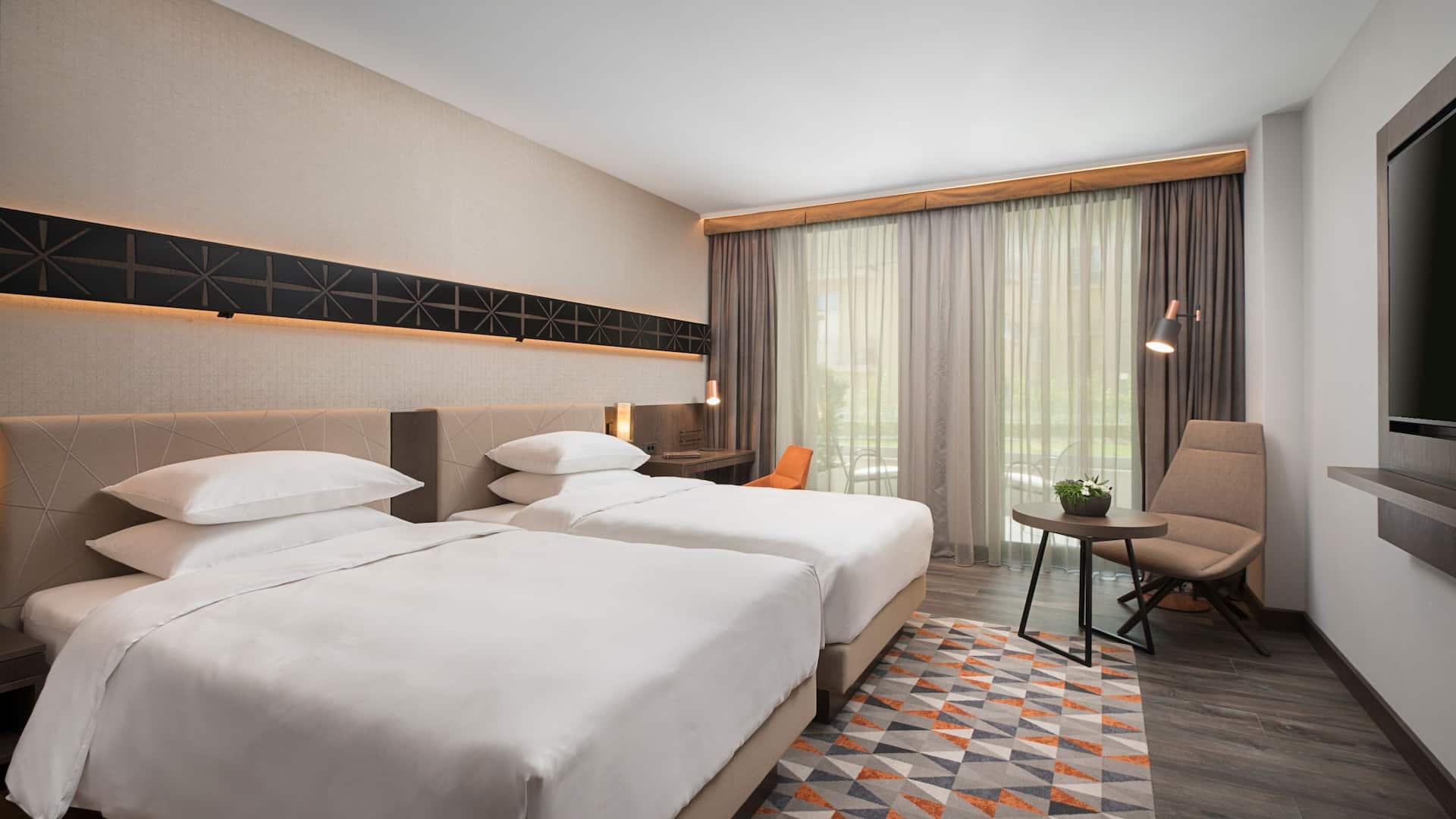 1 из 4 Modern Twin Beds room at Hyatt Regency Sofia, featuring elegant décor, plush bedding, a stylish workspace, and floor-to-ceiling windows with a serene garden view.