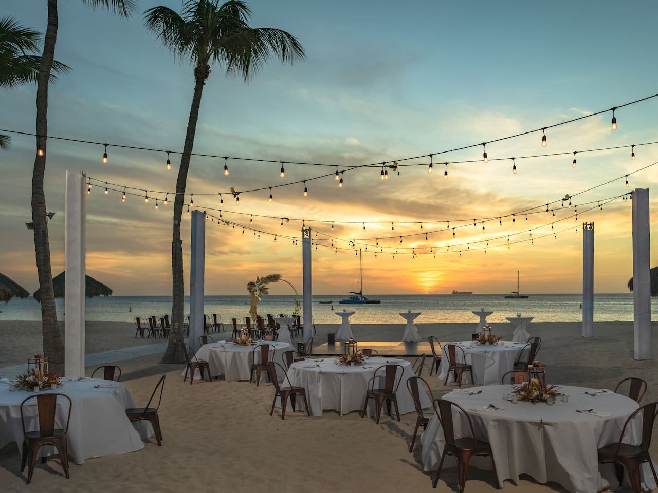 Outdoor dining area on the beach at sunset