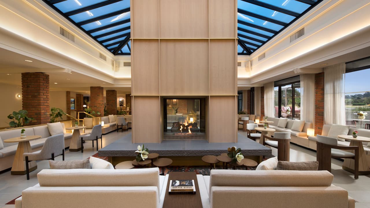Atrium lobby seating area with central fireplace at Hyatt Regency Monterey Hotel and Spa on Del Monte Golf Course