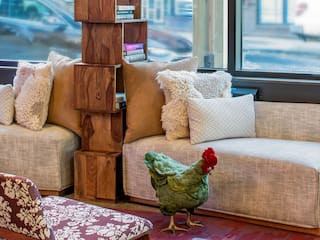 Lobby couch details with cozy pillows, bookshelves, and plush chicken