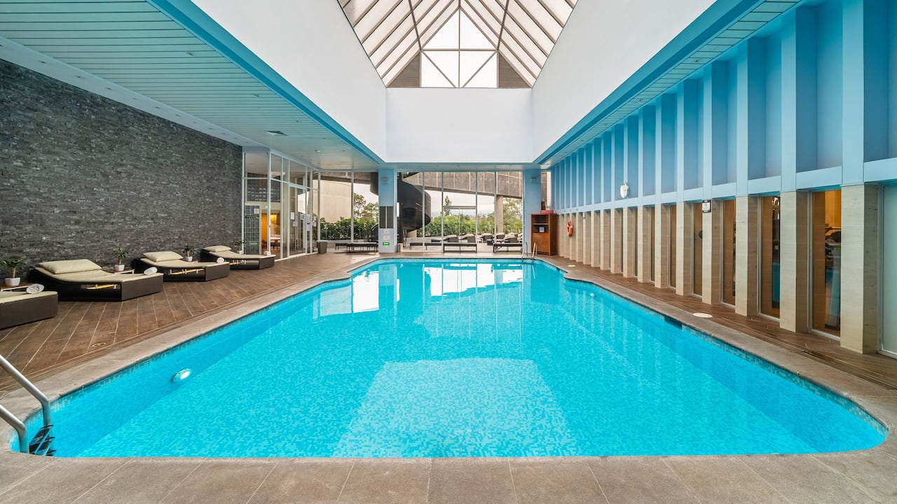 Indoor pool with skylights and lounge chairs