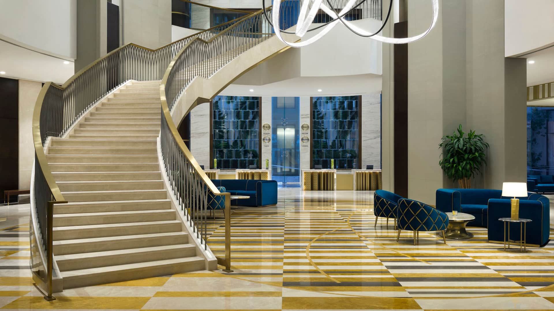 Grand Hyatt Al Khobar luxurious hotel lobby featuring a grand staircase, modern chandeliers, elegant seating, and a sophisticated reception area