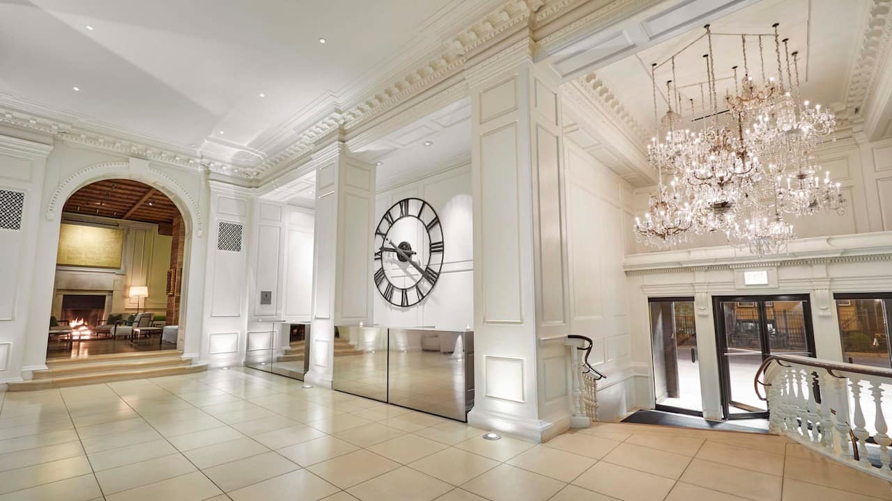Hotel Lobby with luxurious chandelier, large iron clock and white stately walls