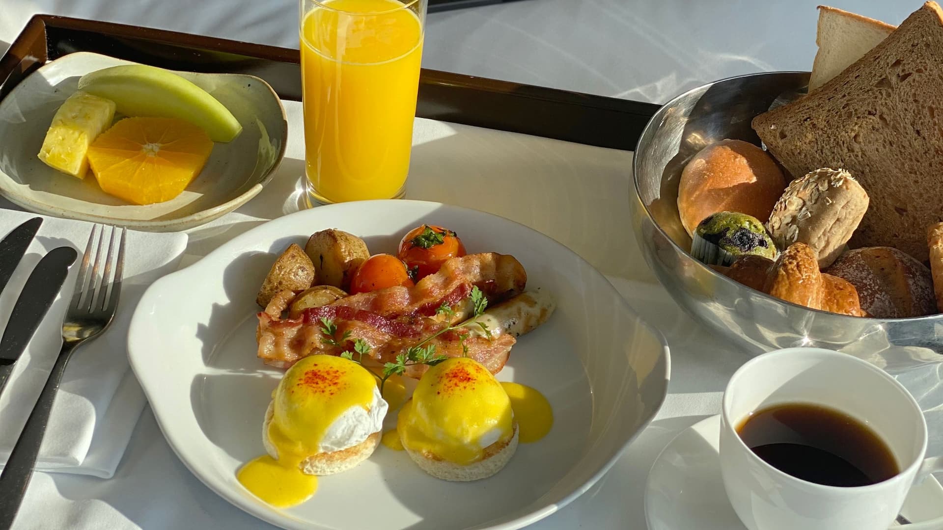 1 of 1 Room service breakfast at Hyatt Regency Stratford London composed of eggs, bacon, pastries and bread on a platter