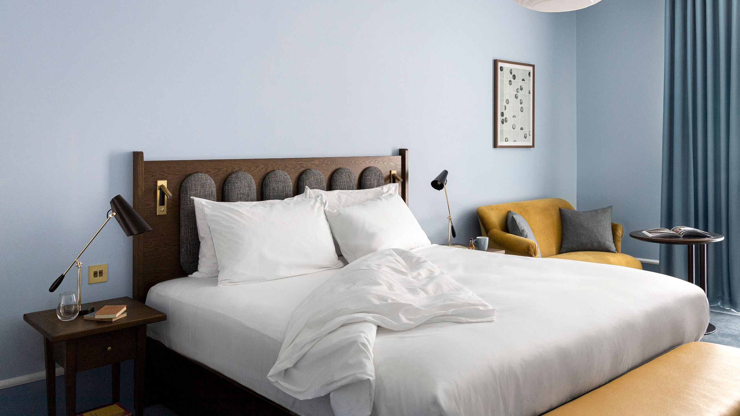 1 of 12 Hotel bedroom, flanked by nightstands with lamps. A yellow armchair and framed art add charm to this inviting space at the upscale Hyatt Centric Cambridge Hotel